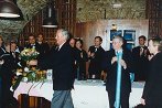 g. Ernst Buchacher, predsednik botrskega RC Hermagor iz Avstrije in g. Schumi pripravljata darili: šopek cvetja in zastavo Rotary International 
